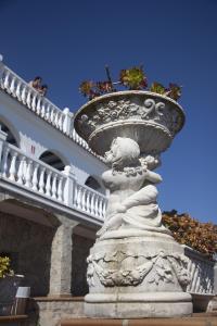 a statue of a woman with a planter on top of a building at Hostal Mar de Frente in Los Caños de Meca