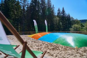 a rainbow colored pool in the sand next to trees at UplandParcs Sauerland in Winterberg