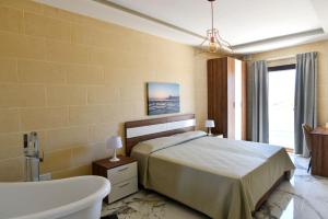 a bedroom with a bed and a bath tub and a bath tub at Azure W B&B in San Lawrenz +37 photos