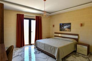 a bedroom with a bed and a large window at Azure W B&B in San Lawrenz