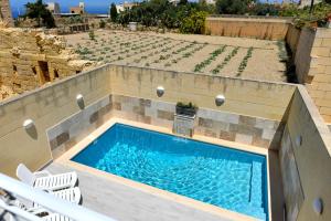 a small swimming pool in a patio with chairs at Azure W B&B in San Lawrenz