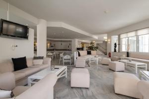 una sala de estar con sofás y mesas blancos. en Dimitrios Beach Hotel Adults Friendly 14 plus en Rethymno Town
