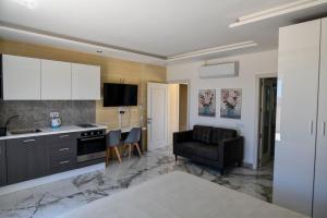 a living room with a kitchen and a couch at Azure W B&B in San Lawrenz