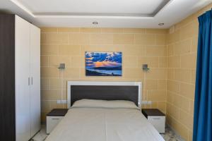 a bedroom with a large bed with two night stands at Azure W B&B in San Lawrenz