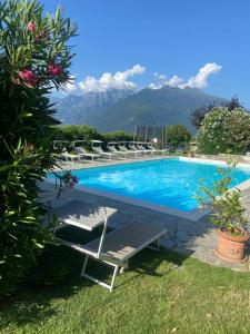 a pool with lounge chairs and mountains in the background at Casa Camilla in Colico