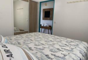 a bedroom with a bed with a comforter on it at Superbe, rénové, au calme, plage 200m, terrasse vue Mer! in Rayol-Canadel-sur-Mer