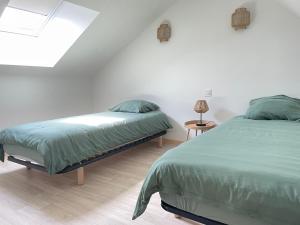 a bedroom with two beds and a skylight at Logement entier à la campagne proche du circuit et du zoo de la Flèche in Yvré-le-Pôlin