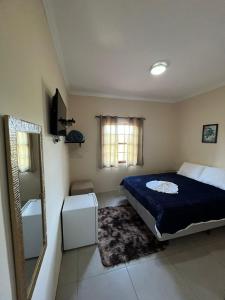 um quarto com uma cama, um espelho e um lavatório em Recanto Lua Clara em Campos do Jordão