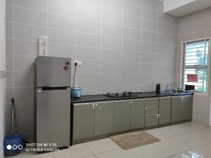 - une cuisine équipée d'un réfrigérateur en acier inoxydable dans l'établissement Pool Smart Tv Wifi 3 aircond room Jitra Kolej Height Utara, à Jitra