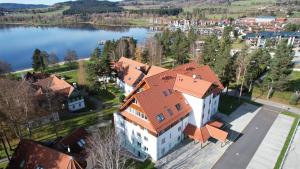 an aerial view of a large building with an orange roof at Apartmány u pláže Lipna - Riviera in Lipno nad Vltavou
