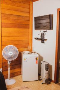 Zimmer mit einem Ventilator und einem kleinen Kühlschrank. in der Unterkunft Pousada Gagno in Domingos Martins
