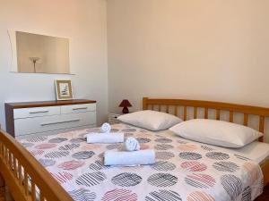 a bedroom with a bed with two towels on it at Apartmani Bona in Biograd na Moru