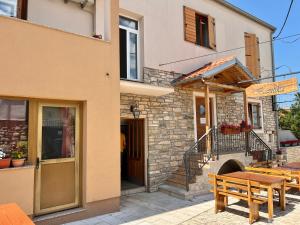 a building with a wooden table and a bench at Apartmani Bona in Biograd na Moru