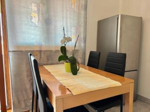 Una mesa de comedor con un jarrón de flores encima. en Apartmani Bona, en Biograd na Moru 9 fotos más