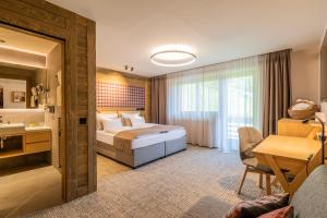 a hotel room with a bed and a bathroom at Hotel OTP Birkenhof in Bad Kleinkirchheim