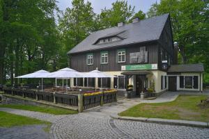 ein Gebäude mit einem Laden mit Sonnenschirmen davor in der Unterkunft Gasthof Ungerberg in Neustadt in Sachsen