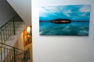 a painting hanging on a wall next to a staircase at Bee Hotel in Vlorë