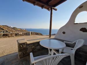 un tavolo e sedie su un balcone con vista sull'oceano di Fanari sea view studios a Fanari