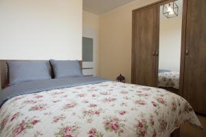 um quarto com uma cama com colcha floral em Mieszkanie Zielony Targówek em Varsóvia