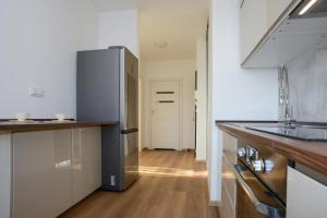 uma cozinha com um frigorífico em aço inoxidável e pisos em madeira em Mieszkanie Zielony Targówek em Varsóvia