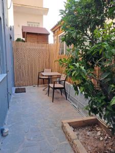 a patio with a table and chairs next to a fence at ANAFIS COZI in Athens