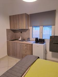 a kitchen with wooden cabinets and a yellow bed at ANAFIS COZI in Athens