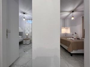 - une chambre blanche avec un lit et une chambre avec dans l'établissement Aem House, à Prinos