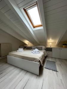 um quarto no sótão com uma cama e uma clarabóia em Aquadolce em Baveno