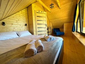 a bed in a wooden room with towels on it at Jaworowe Wzgórze in Wysowa-Zdrój