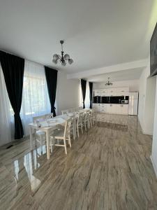 a dining room with white tables and white chairs at Casa Lucia in Sibiu