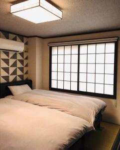 a bedroom with a large bed and a large window at Kulton Moct Kenroku in Kanazawa