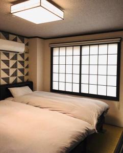 金沢市にあるKulton モースト 兼六のベッドルーム(大型ベッド1台、大きな窓付)