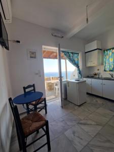 a kitchen with a table and chairs and a kitchen with a view at Fanari sea view studios in Fanari