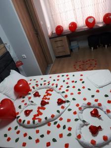uma cama com corações vermelhos com uma colcha com rosas em esas pansiyon em Gemlik