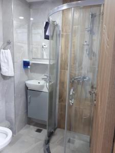 uma casa de banho com um chuveiro, um WC e um lavatório. em esas pansiyon em Gemlik