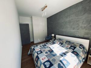 a bedroom with a bed with a quilt on it at Apartament Amilado in Pogorzelica