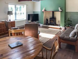 a living room with a table and a fireplace at The Croft in Longhorsley