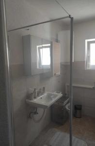 a bathroom with a sink and a toilet at Ajsha Guesthouse in Jajce