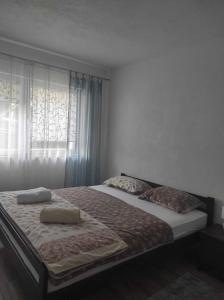 a bedroom with a bed with two pillows and a window at Ajsha Guesthouse in Jajce