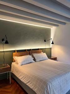 a bedroom with a large bed with two lamps on it at Casa Giotto in Padova