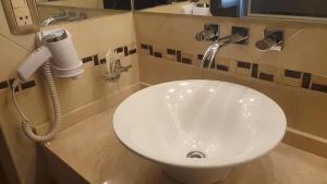 y baño con lavabo blanco y secador de pelo. en Hotel Pueblo Huarpe en San Luis