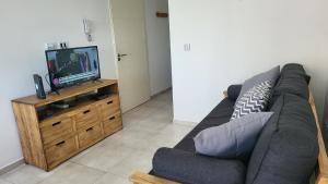 a living room with a couch and a television at Luminoso departamento en Morón in Morón