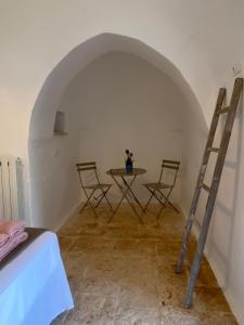 une chambre avec une table, des chaises et une échelle dans l'établissement Trullo Porta Celeste, à San Michele Salentino