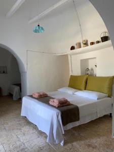 ein Schlafzimmer mit einem Bett in einem weißen Zimmer in der Unterkunft Trullo Porta Celeste in San Michele Salentino