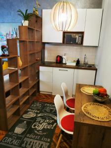 cocina con mesa, sillas y microondas en Apartman Jovana 2, en Belgrado