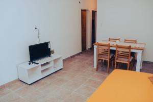 a living room with a television and a table with chairs at Apart Las 3 Marias in Chilecito