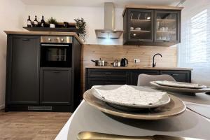 a kitchen with black cabinets and a table with plates at AR Apartments III I 4 Pers I Modern I Schillerapartment in Rudolstadt