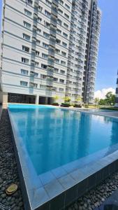 a large swimming pool in front of a large building at AVIDA TOWER Free Airport Pick up for 3 nights stay or more in Davao City
