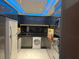 a kitchen with a washer and dryer and blue ceilings at Villa Nour in El Jadida