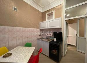 a small kitchen with a table and a stove at Veyasum Guest House in Ganja